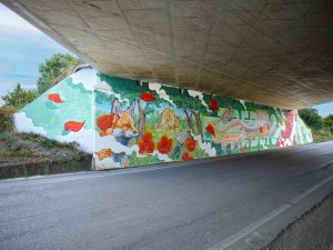 Photo of Chus’s mural under a highway overpass in Italy, depicting the allegory of wild Nature