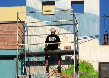 Photo of the artist Chus working on his Lagoon mural