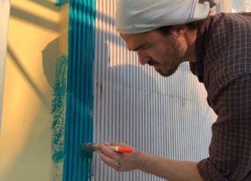 Photo of the artist Chus working on his Lagoon mural