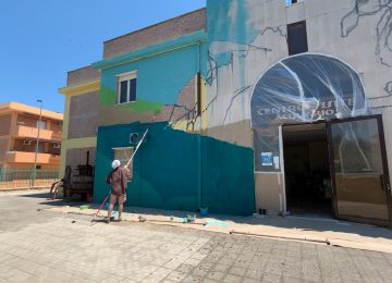 Photo of the artist Chus working on his Lagoon mural