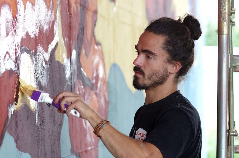 Photo of the artist Chus working on the mural Terra in Sansepolcro