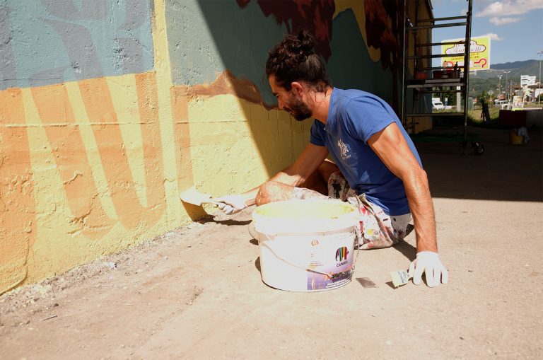 Photo of the artist Ivan Tresoldi working on a mural in Sansepolcro