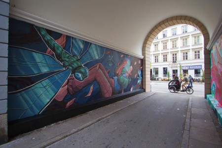 angle view of Mural with a Girl a glowy jar dragonflies and leaves Street Art by Chus for Westend Walls in Copenhagen